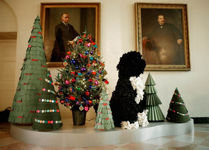 Những cây thông Noel và chó Bo được làm từ giấy đặt phía trước bức chân dung của cựu Tổng thống Calvin Coolidge và Grover Cleveland trong Phòng Vườn Đông.