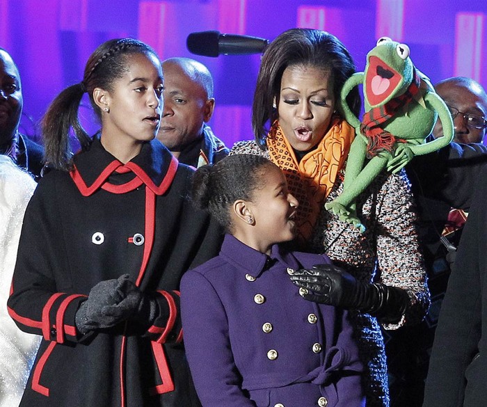 Đệ nhất phu nhân Michelle Obama, Ếch Kermit cùng hát bài hát vui vẻ với cô con gái Malia (trái) và Sasha sau khi thắp sáng cây Giáng sinh khổng lồ phía trước Phòng Bầu Dục của Nhà Trắng hôm 1/12.