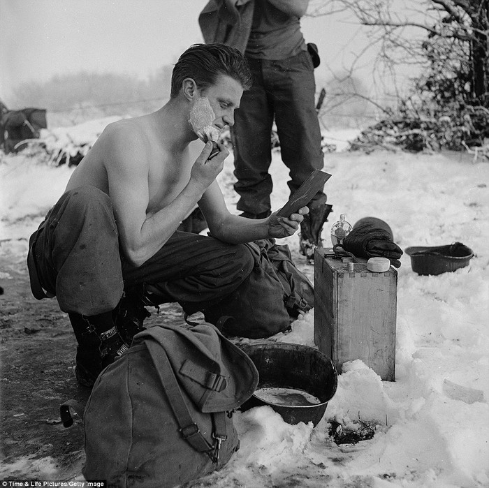 Một lính Mỹ mình trần cạo râu trong thời tiết lạnh giá khi cuộc chiến tạm lắng xuống trong trận Battle of the Bulge
