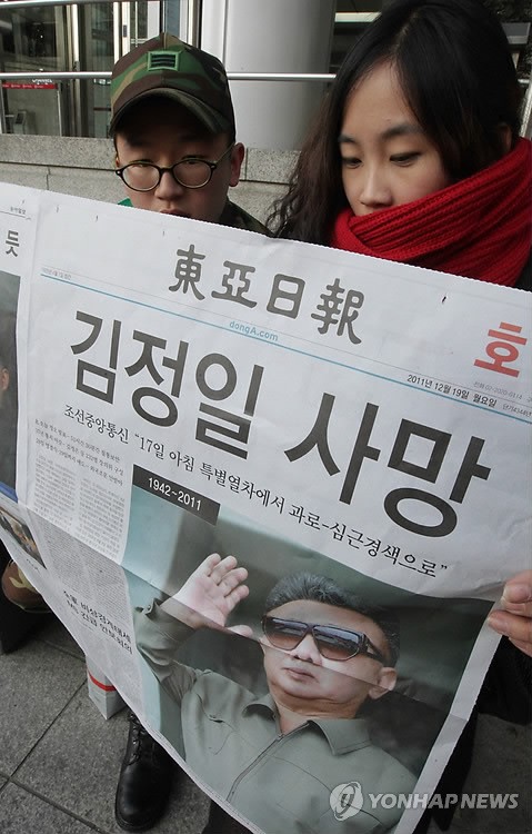 Người dân Hàn Quốc đọc báo có đăng tải tin tức về cái chết của Chủ tịch Kim tại Seoul