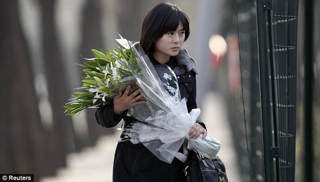 Một cô gái Triều Tiên mang hoa tới hàng rào Đại sứ quán tại Bắc Kinh, Trung Quốc để tưởng niệm cái chết của Chủ tịch Kim