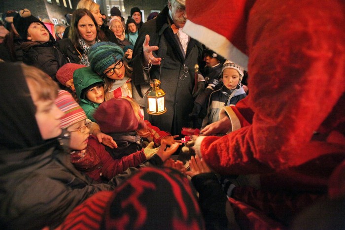 Những đứa trẻ thích thú nhận kẹo từ một ông già Noel phía trước của nhà thờ St Petri ở Luebeck, Đức ngày 23/11/2011