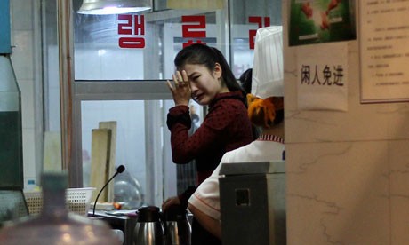 Một nữ bồi bàn khóc phía sau một nhà hàng Triều Tiên tại Bắc Kinh khi nghe tin Chủ tịch Kim đã qua đời