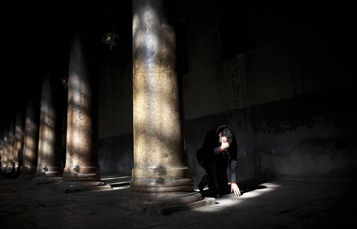 Một tín đồ đang cầu nguyện trong Nhà thờ Giáng sinh ở thành phố Bethlehem