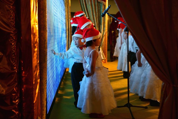 Những em bé tham gia hát đồng ca bài hát Giáng sinh tại trung tâm mua sắm Giáng sinh ở Bắc Kinh, Trung Quốc