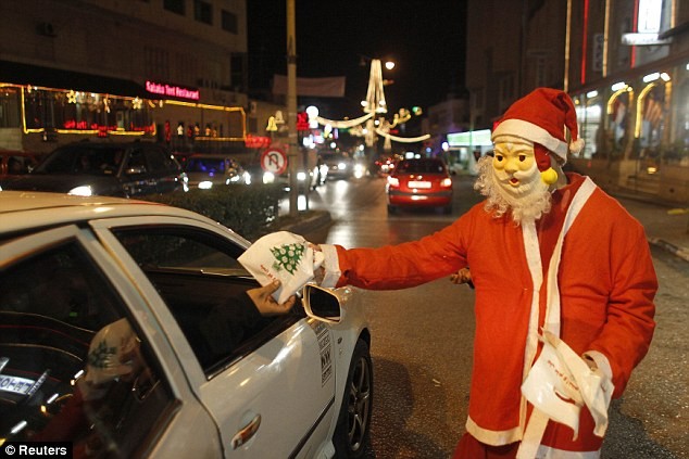 Một ông già Noel tặng quà cho trẻ em trên quảng trường Manger trong đêm Noel