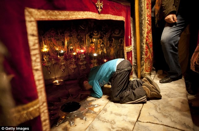 Một cậu bé cầu nguyện tại hang trong nhà thờ Bethlehem