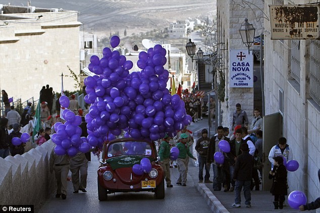 Chiếc xe hơi mang bóng bay phát cho người dân tại Bethlehem trước lễ Giáng sinh