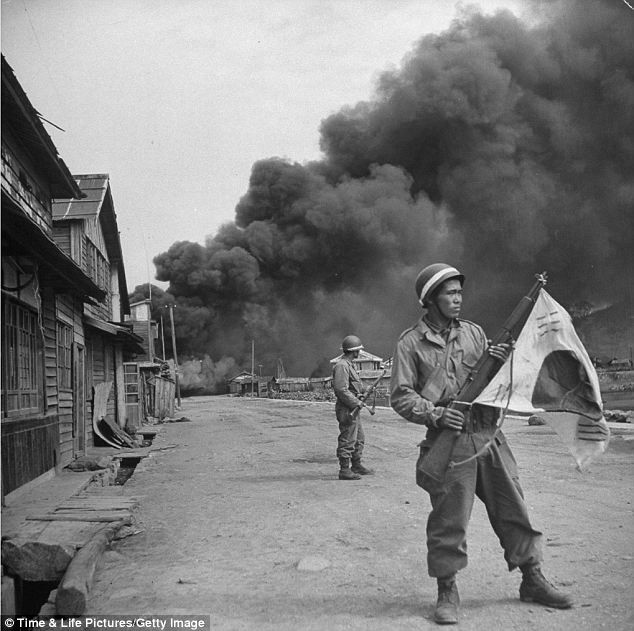 Lính Hàn Quốc tại một ngôi làng đang bốc cháy vì trúng bom