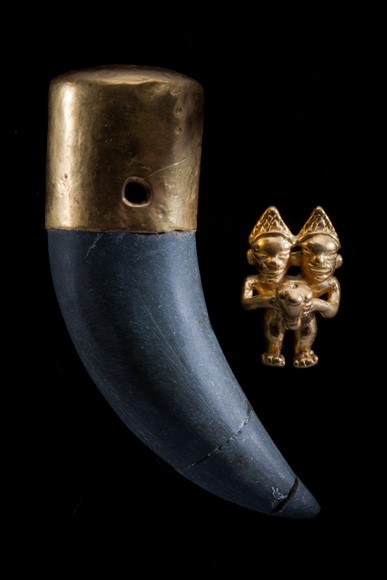 Một mặt dây chuyền vàng dài 6 cm và bức tượng chiến binh được tìm thấy chôn cùng nhau