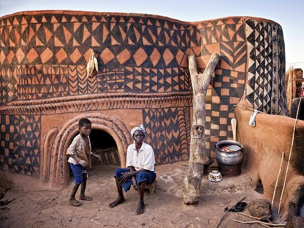 Một người đàn ông và đứa bé trai ở phía trước căn nhà của họ tại Tiebele, làng sơn của người Gurunsi ở phía nam Burkina Faso. Ảnh Louis Montrose