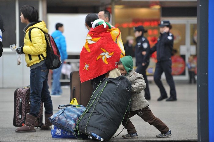 Một cậu bé cố gắng dựng túi hành lý "khổng lồ" của gia đình trước cửa ga Quý Châu, tỉnh Quý Dương ngày 8/1