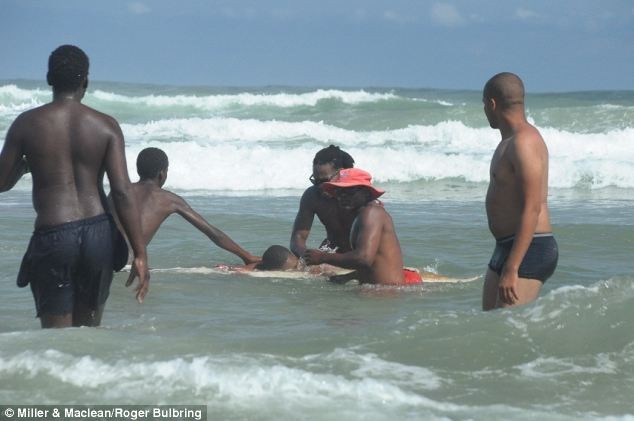 Các nhân viên cứu hộ cố gắng đưa Msungubana vào bờ để cấp cứu bằng một chiếc ván