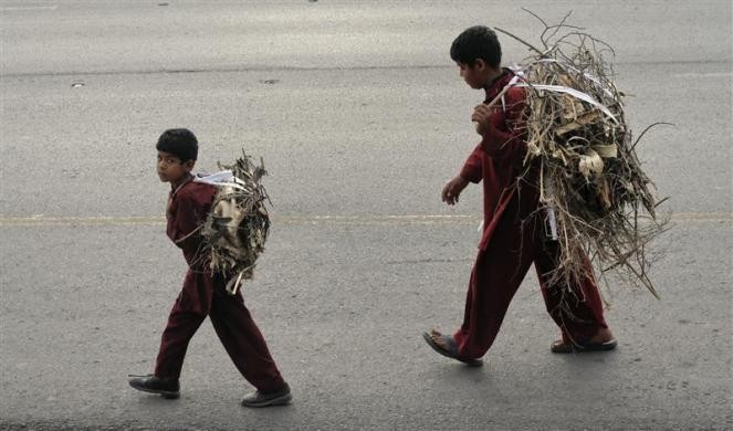 Những cậu bé vác củi khô dùng để nấu ăn đi bộ về nhà ở Islamabad, Pakistan ngày 21/11/2011
