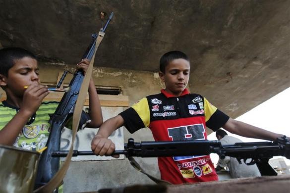 Các cậu bé lau súng cho các chiến binh nổi dậy ở Misrata, sau khi họ trở về từ tiền tuyến ở ngoại ô Zlitan, Libya ngày 12/7/2011