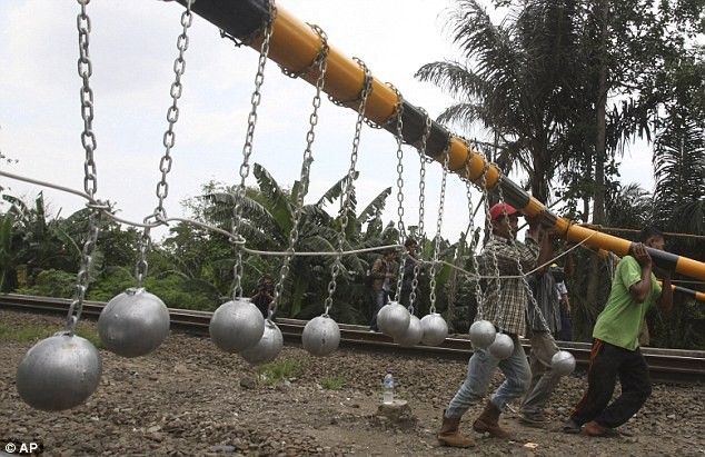 Những người công nhân đang dựng thanh chắc tàu có bóng sát ở Bekasi, Tây Java, Indonesia