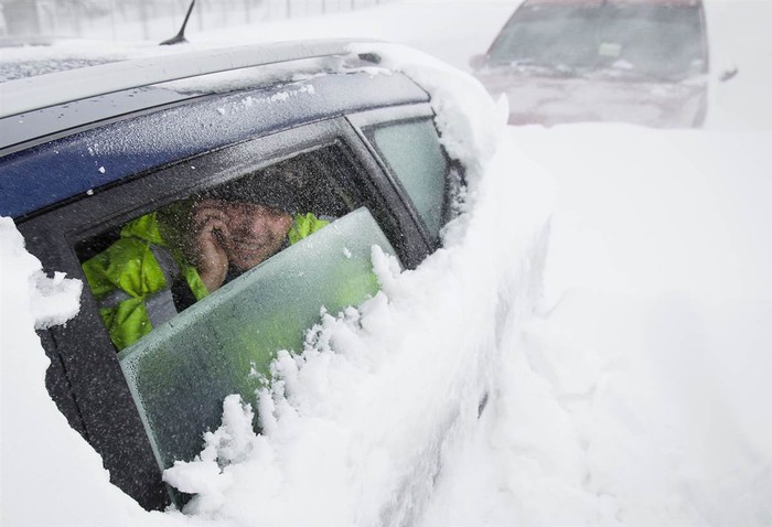Một người đàn ông đang nói chuyện qua điện thoại từ bên trong chiếc xe bị kẹt trong tuyết dầy ở ngoại ô Bucharest, Romania ngày 26/1. Bão tuyết lớn đã khiến cả miền nam và miền đông Romania bị tê liệt trong những ngày qua.