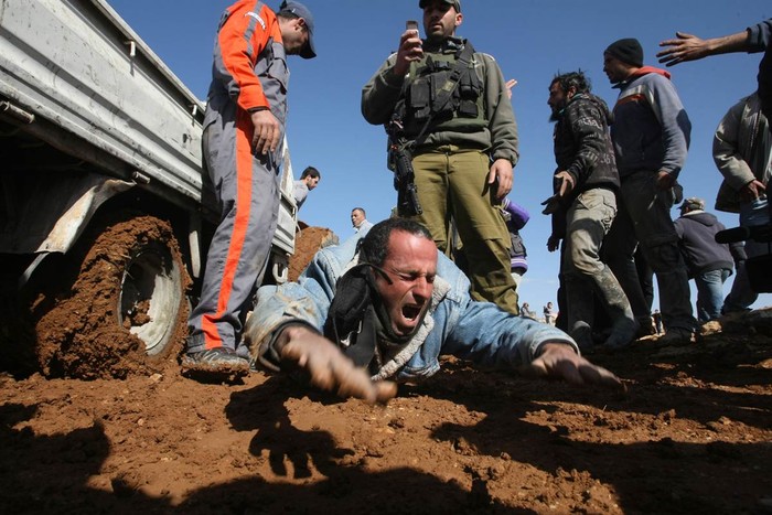 Một thợ xây Palestine hét lên vì đau đớn sau khi bị một binh sĩ Israel đẩy chiếc máy kéo lên chân của ông ở gần Yatta, Bờ Tây ngày 25/1. Lực lượng Israel đã thu giữ thiết bị của các công nhân Palestine vì cho rằng họ đã xây nhà tại khu vực cấm xây dựng.