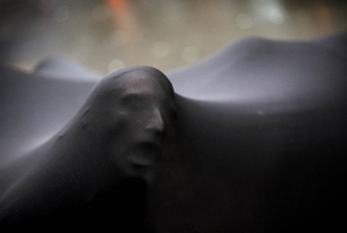 Hình ảnh khuôn mặt đáng sợ của một người biểu tình chiếm phố Wall khi núp bên dưới một tấm màn màu đen ngày 20/1