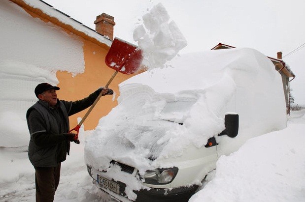 Petre Andrei, 56 tuổi, xúc tuyết phủ kín chiếc xe của mình tại Movillita, cách Bucharest khoảng 45 km.