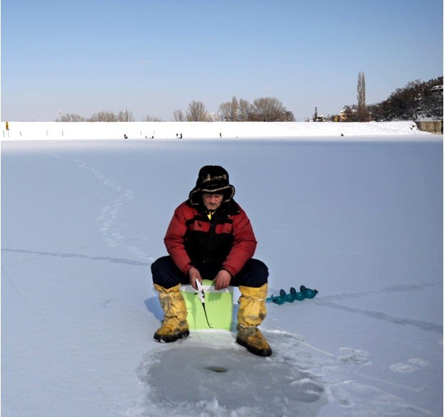 Một người câu cá trên hố băng gần thủ đô Sofia, Bulgaria. Một số khu vực tại quốc gia này nhiệt độ đã giảm xuống tới -27 độ C