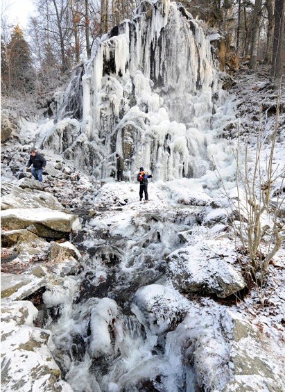 Một người đang leo lên thác nước Radau đã đóng băng ở Bad Harzburg, Đức
