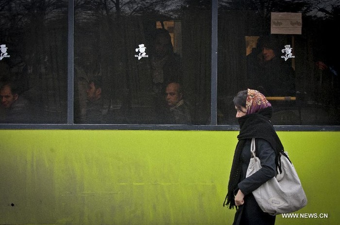 Một cô gái đi bộ ngang quan bến xe bus tại Tehran ngày 2/2