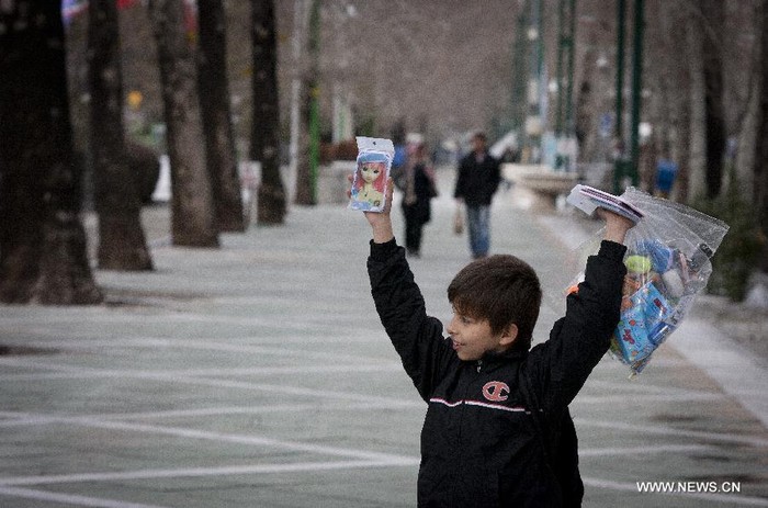 Cậu bé bán hàng dạo trên hè phố Tehran ngày 2/2
