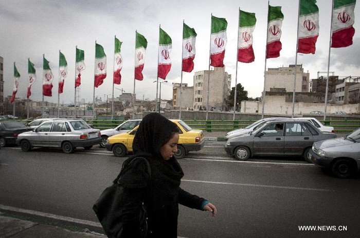 Một phụ nữ đi bộ qua con phố ngập quốc kỳ Iran tại phía bắc thủ đô Tehran ngày 2/2