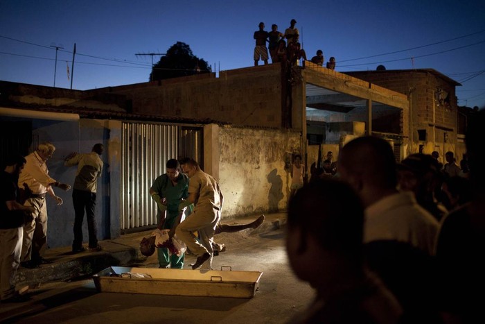 Nhân viên nhà xác thu gom thi thể của một người đàn ông bị giết trong vụ nổ súng tại Itinga, gần Salvador, Brazil ngày 8/2. Khoảng 1/3 trong số 30.000 cảnh sát tuần tra bang Bahia đã đình công tuần trước khiến nạn cướp bóc, bạo lực và giết người tại Salvador lan rộng và tăng gấp đôi.