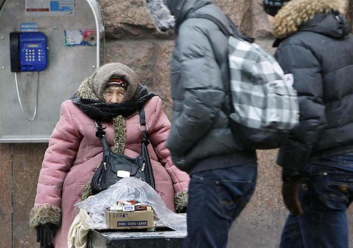 Một phụ nữ lớn tuổi trang bị nhiều áo ấm để bán thuốc lá cho người qua đường tại trung tâm thành phố Kiev, Ukraina hôm 3/2 bất chấp thời tiết lạnh kỷ lục đã giết chết hơn 135 người tại đất nước này những ngày qua.