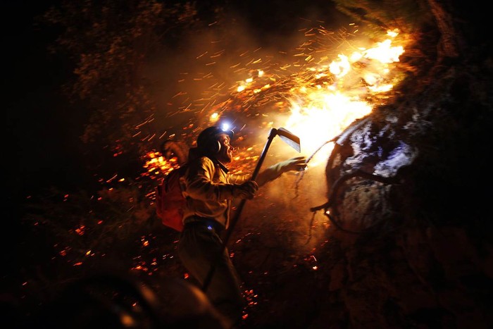 Lính cứu hỏa trèo lên núi để dập tắt đám cháy rừng tại Jubrique, gần Malaga, Tây Ban Nha ngày 5/2.