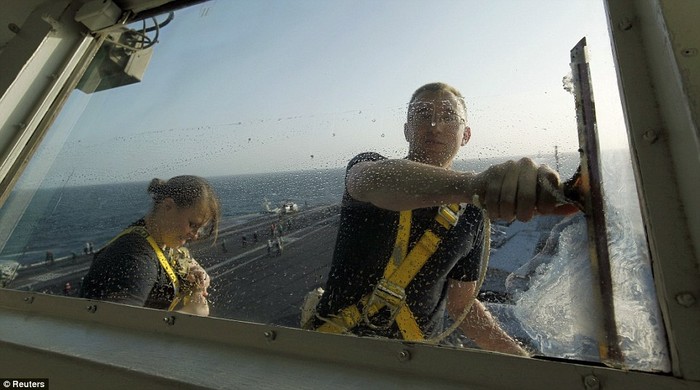 Thủy thủ Mỹ làm sạch kính trên tàu USS Abraham Lincoln
