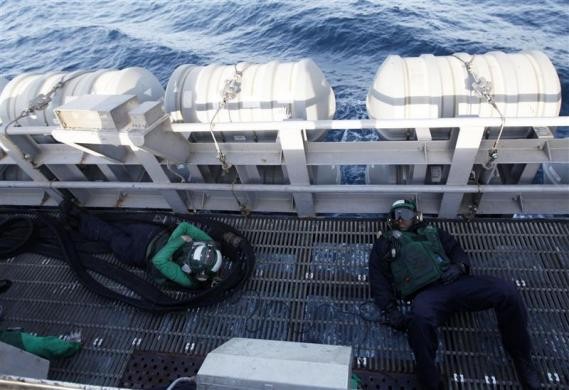 Thủy thủ tranh thủ nghỉ ngơi trên sàn tàu trong lúc chờ đợi tiếp nhiên liệu cho máy bay ngày 14/2/2012