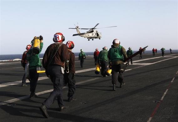 Nhân viên sân bay chạy tới đón một chiếc chiến đấu cơ chuẩn bị hạ cánh hôm 14/2/2012