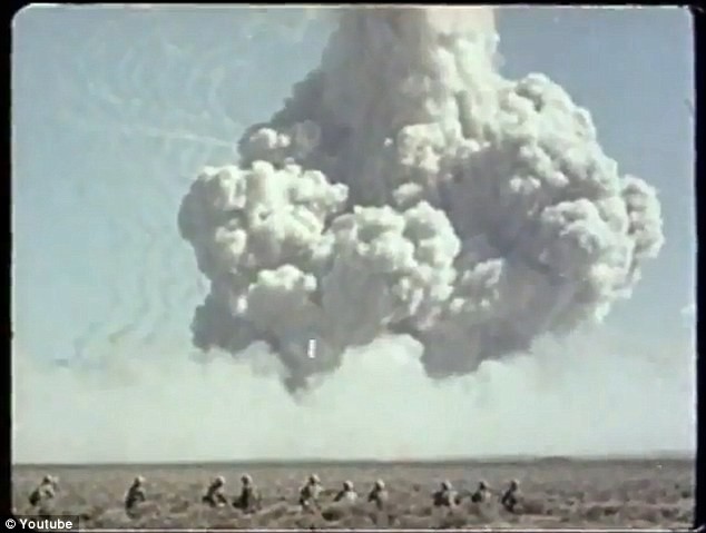 Một nhóm lính Mỹ nhìn đám mây hình nấm đang mở rộng trên bầu trời
