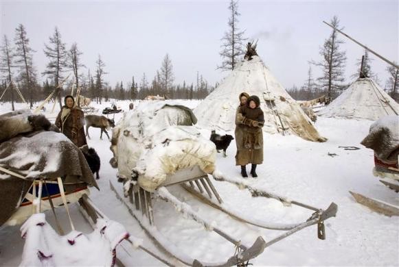 Phụ nữ Nenets đứng cạnh những chiếc xe chất đầy đồ đạc trên bán đảo Yamal