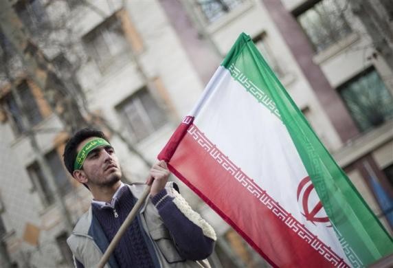 Một sinh viên thuộc lực lượng dân quân Basij, một phần của Lực lượng Cảnh sát cách mạng Iran, cầm quốc kỳ trong cuộc biểu tình trước trụ sở Liên Hiệp Quốc tại Tehran ngày 27/2/2011.