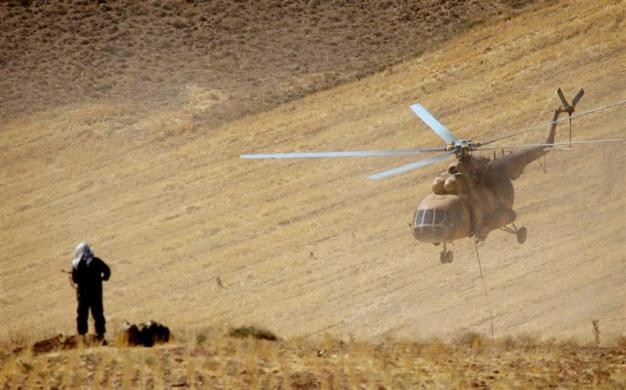 Một tay súng bắn tỉa Iran đứng trên đồi phía trước một chiếc trực thăng trong cuộc tập trận của IRGC tại miền tây Iran ngày 18/9/2004.