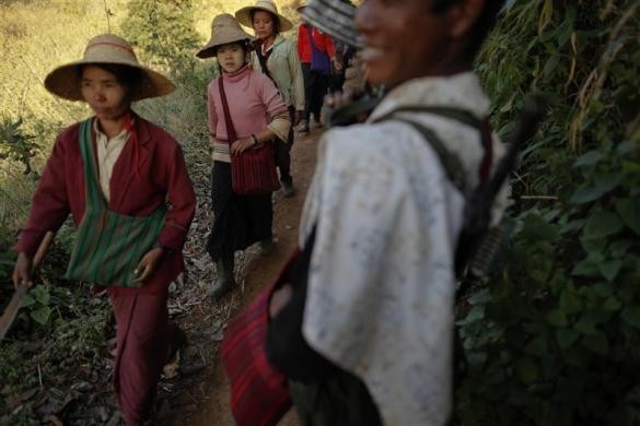 Dân làng Ho Hwayt đi qua một tay súng sau khi tiêu hủy cánh đồng thuốc phiện ngày 26/1/2012.