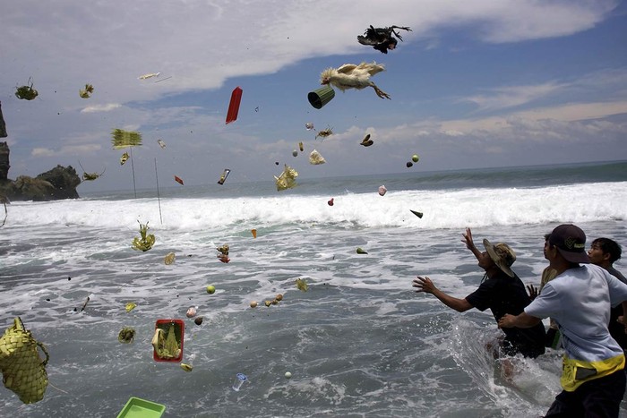 Những người đàn ông đang cố tóm lấy các món vật hiến tế của người Hindu được ném đi trong lễ Melasti trên một bãi biển ở Gunung Kidul, Indonesia, ngày 07 tháng 3.