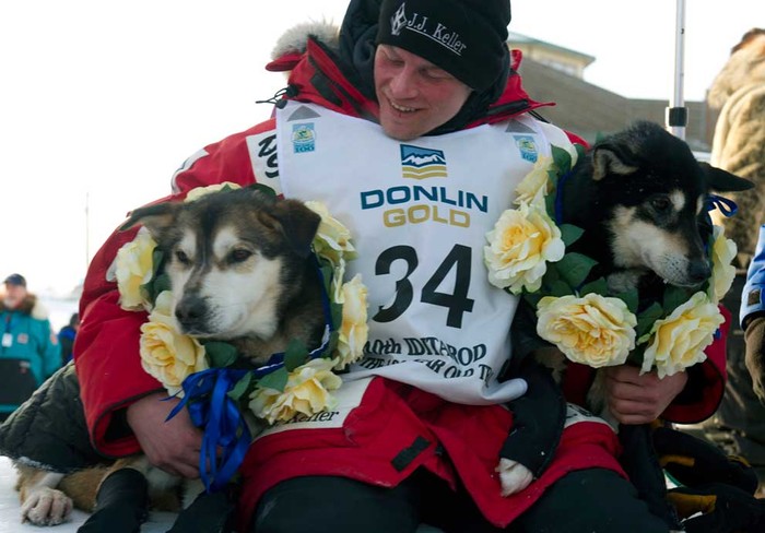 Dallas Seavey ôm chú chó đầu đàn (trái) đã giúp anh giành danh hiệu người chiến thắng trẻ tuổi nhất trong lịch sử giải "Iditarod Trail Sled Dog Race" tại Nome ngày 13/3.