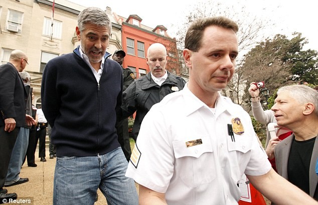 Clooney bị bắt và bị còng tay giải đi