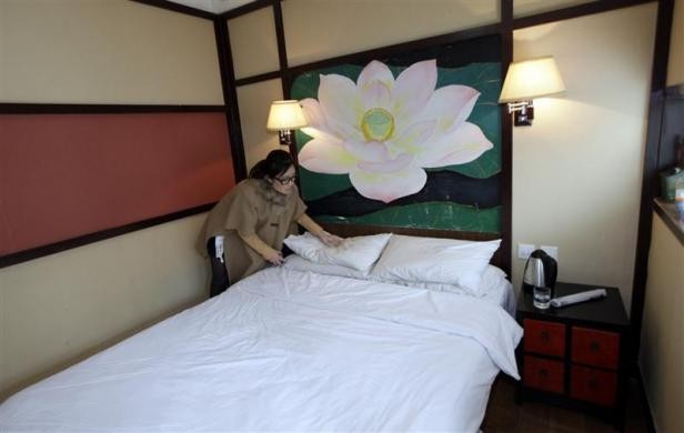 Kiểm tra giường ngủ của một khách sạn được thiết kế theo phong cách truyền thống.