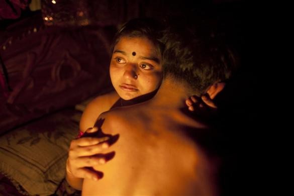 Hashi (17 tuổi) đang ôm người "chồng" tên là Babu của mình trong một căn phòng nhỏ của cô tại nhà chứa Kandapara ở Tangail, một thành phố phía đông bắc của Bangladesh ngày 4/3/2012.
