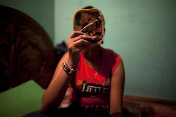 Gái điếm Mukti (12 tuổi) trang điểm trước khi tiếp khách trong căn phòng nhỏ của mình tại nhà chứa ở Faridpur ngày 22/2/2012.