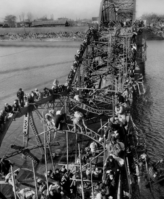 Người dân đi sơ tán đang phá hủy cây cầu Daedong nối liền với Hàn Quốc ngày 4/12/1950.