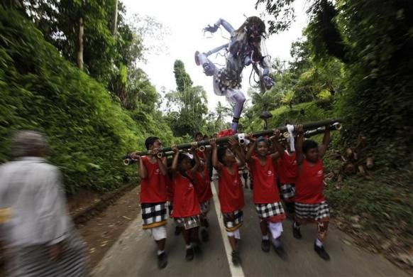 Trẻ em Bali khênh hình nộm Ogoh-ogoh trong nghi lễ tổ chức tại Ubud Gianyar, Bali ngày 21/3