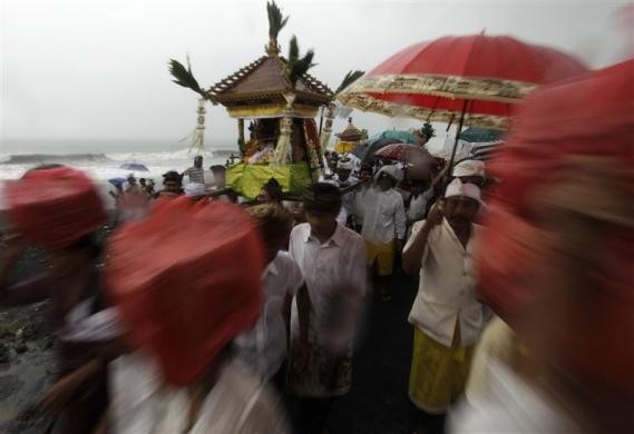 Người dân rước kiệu Pratima, một biểu tượng tôn giáo, trên bãi biển trong lễ hội Melasti tại huyện Gianyar, Bali ngày 21/3