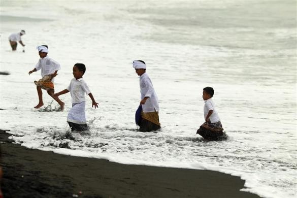 Trẻ em chơi đùa trên bãi biển trong lễ Melasti tại huyện Gianyar, Bali ngày 21/3